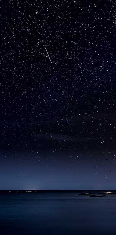 Starry night sky over tranquil ocean, stargazing scene