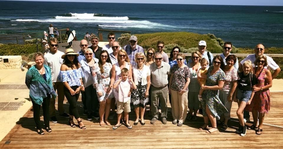 Coastal winery tour group posing on oceanfront deck at seaside