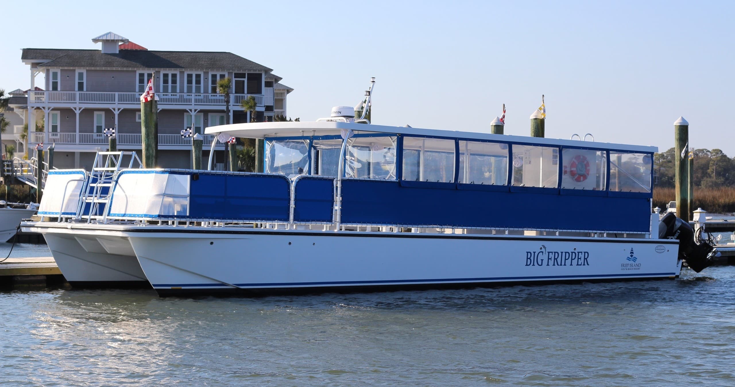 Sightseeing ferry docked in coastal harbor, waterfront tour vessel