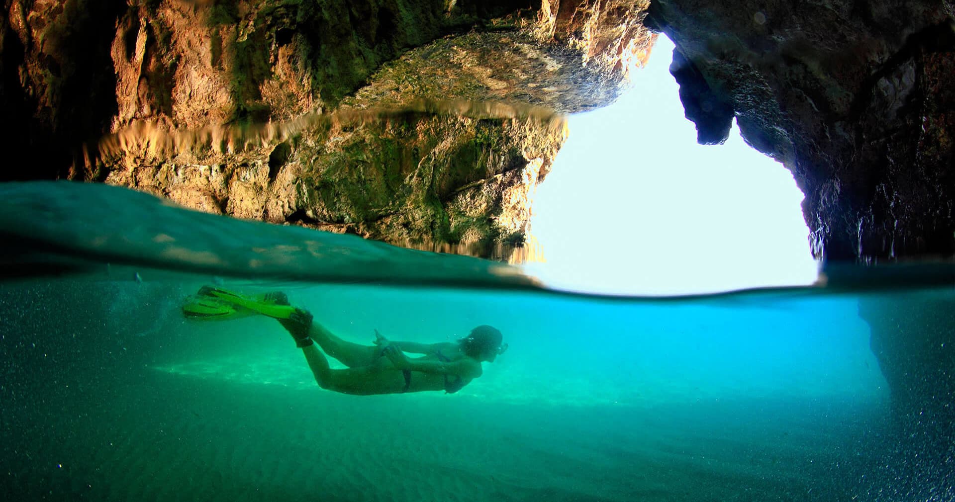 Yacht cruising coastal cliffs over turquoise sea, scenic boat tour