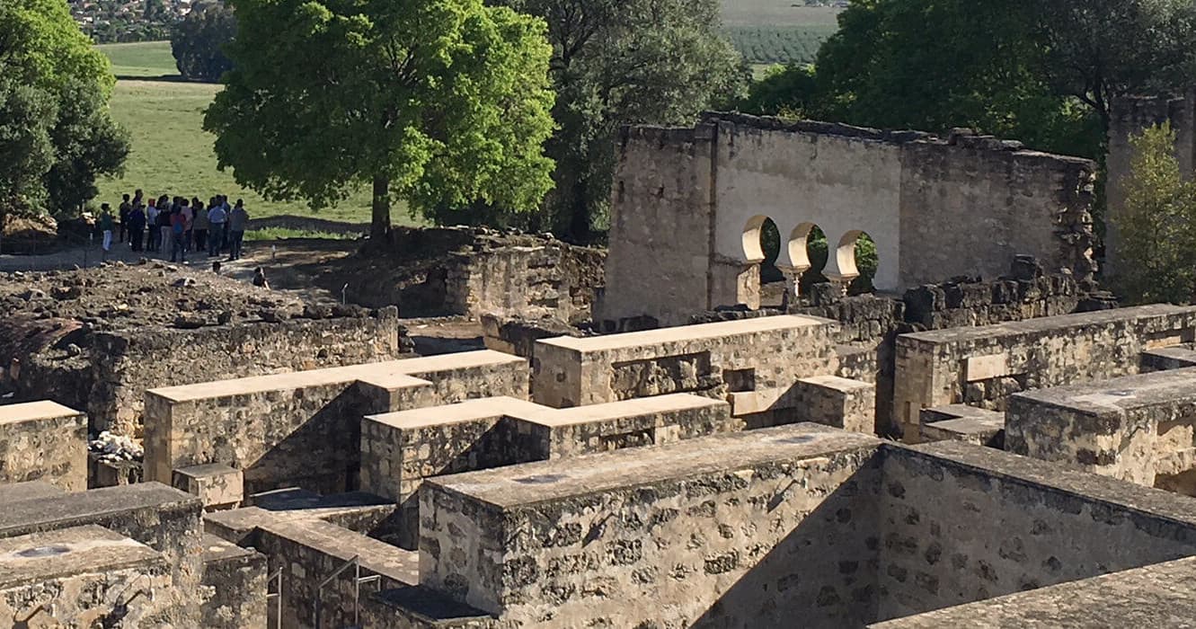 Archaeological foundations and visitors exploring Medina Azahara ruins