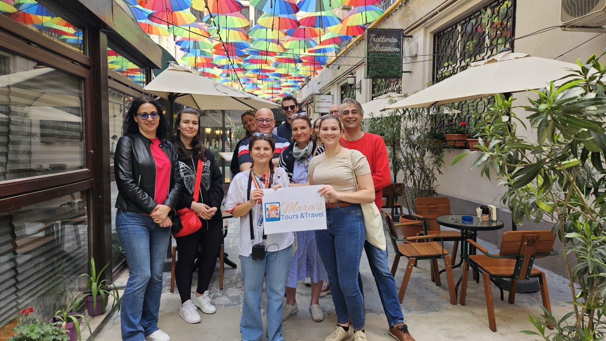 Walking tour group under colorful umbrella canopy in alley