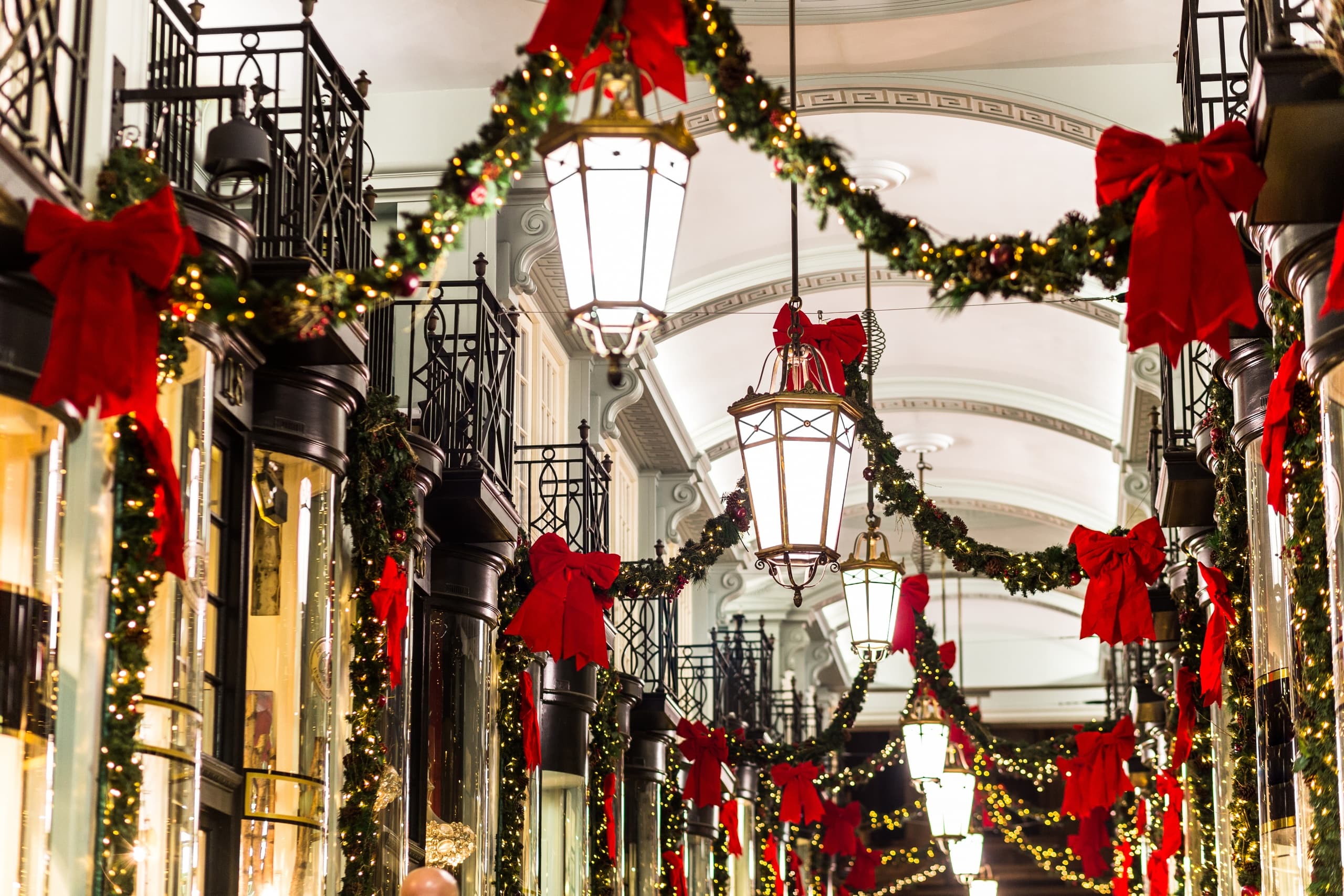 Festive holiday shopping arcade with garlands and red bows indoors