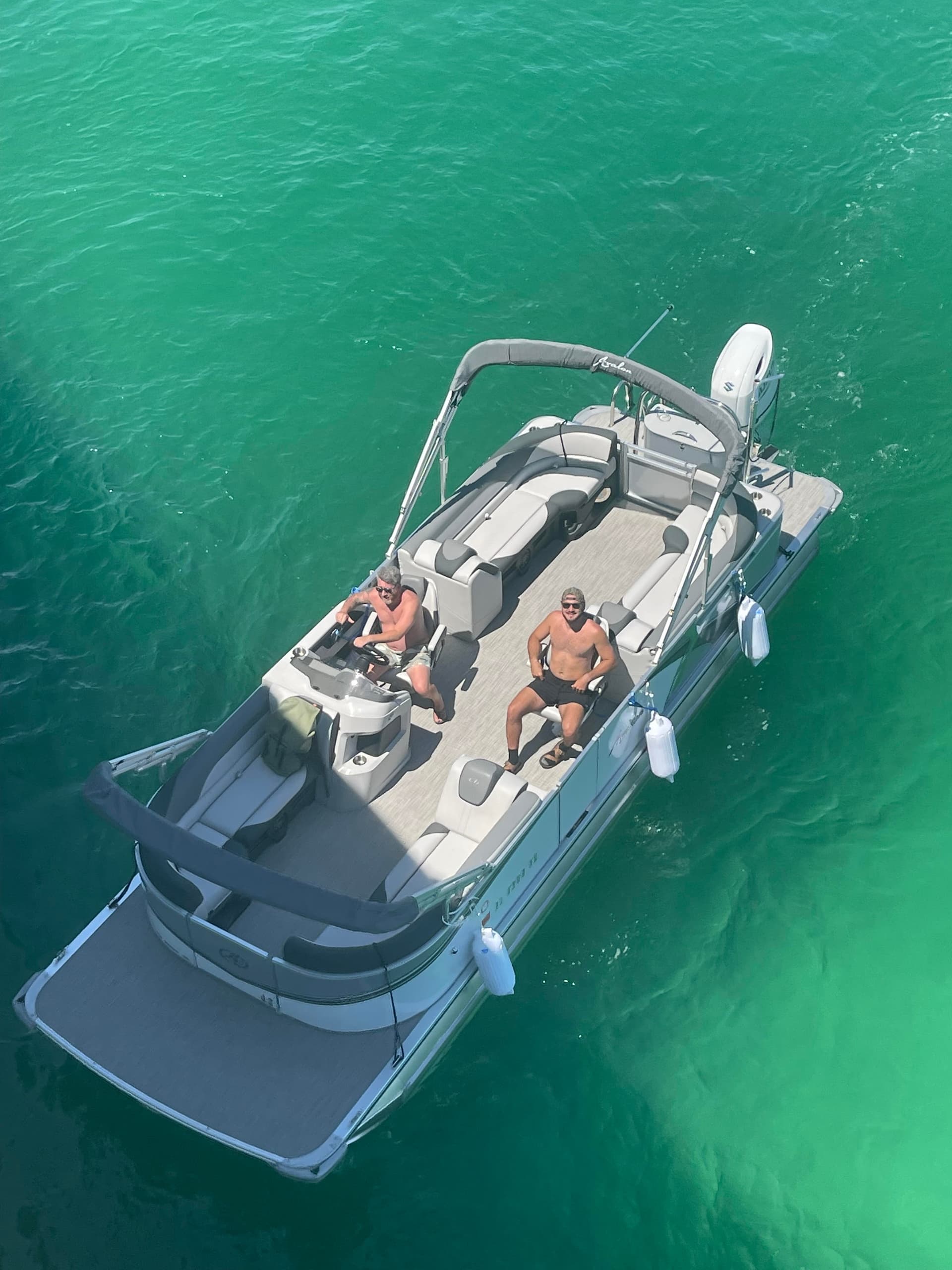 Top-down drone shot of pontoon anchored in turquoise sea