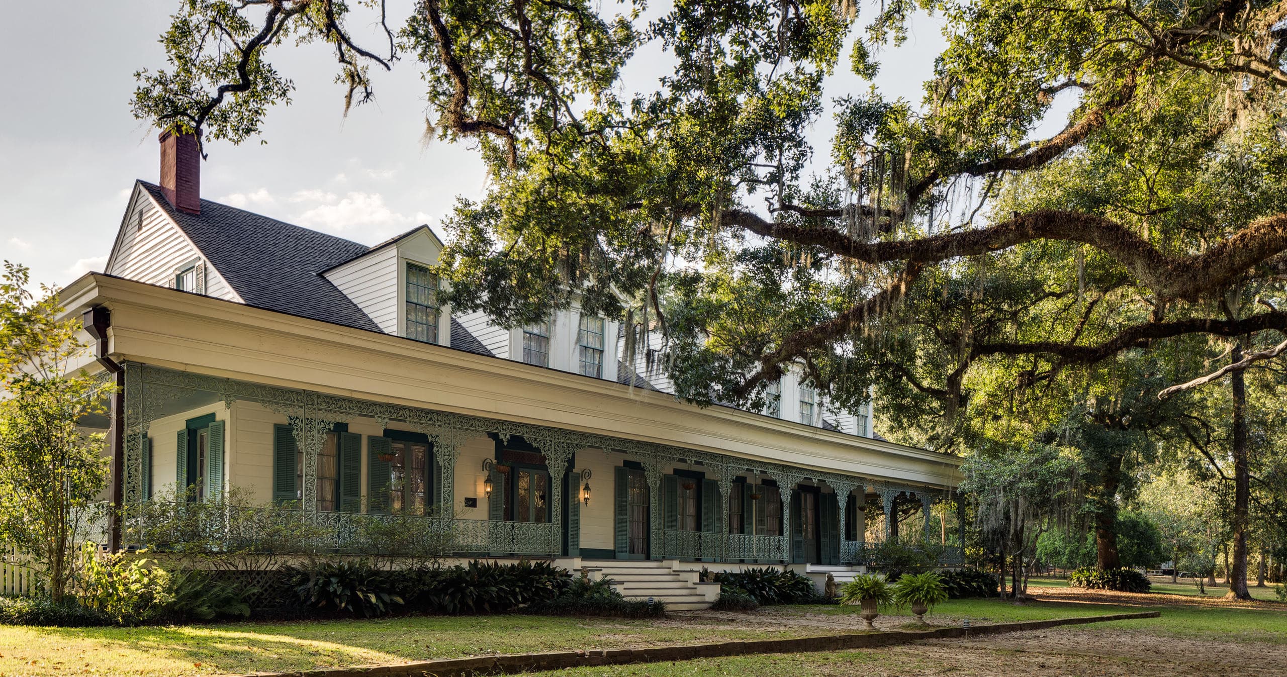 Long plantation veranda shaded by live oaks and lawn