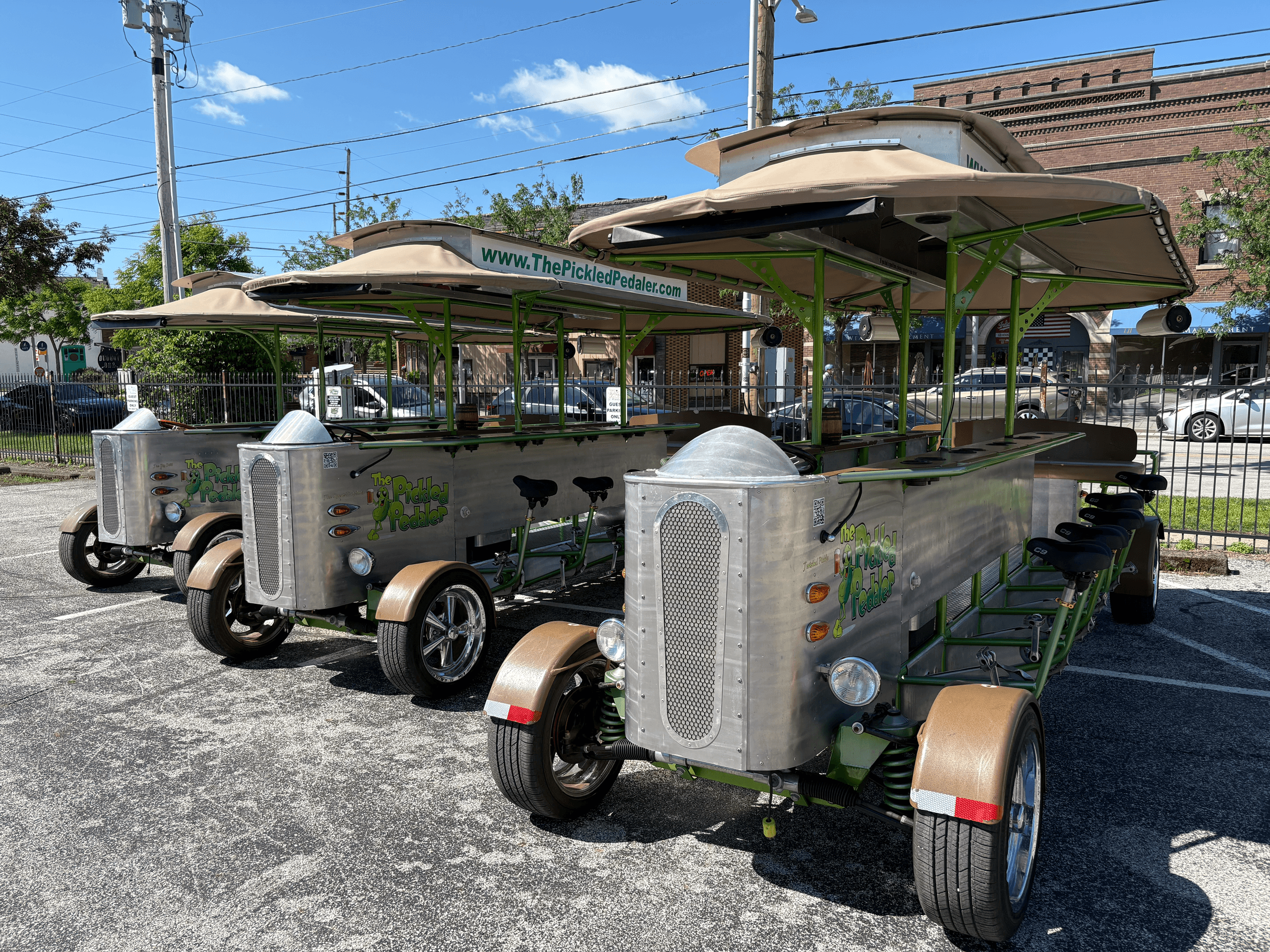 Parked pedal pub fleet under blue sky on asphalt lot