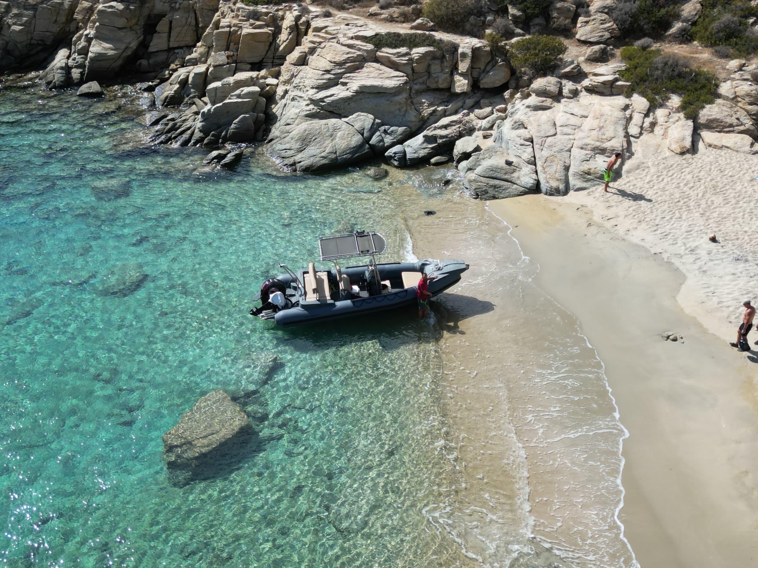 Aerial view of rib boat on a secluded Mediterranean sandy cove