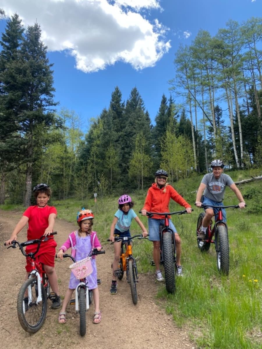 Family mountain biking on forest trail through aspen woods