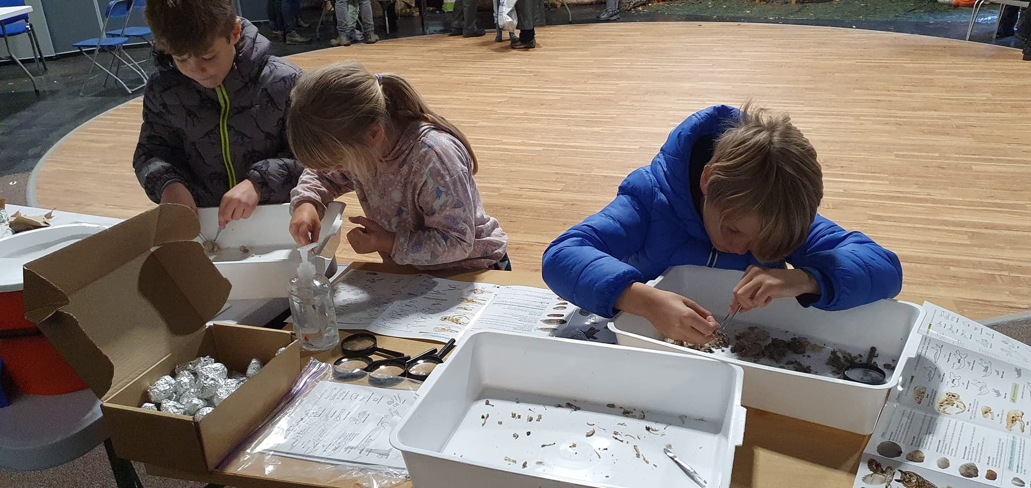 Children doing nature crafts indoors at community center table