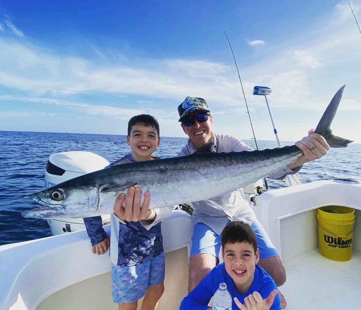 Family posing with a large wahoo on offshore fishing charter