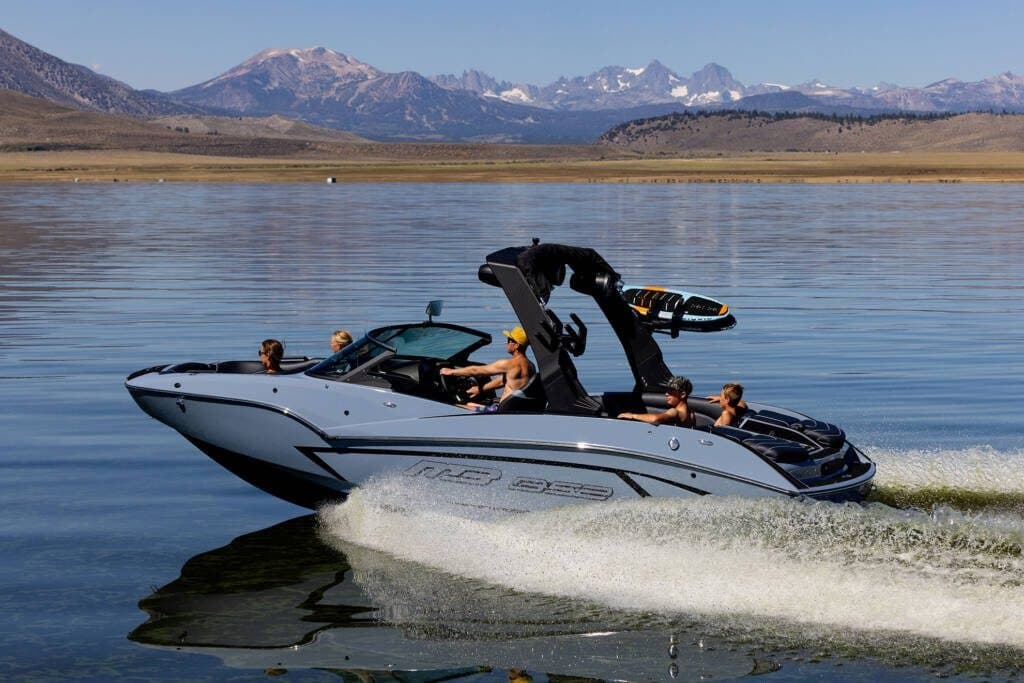 Speedboat cruising near mountain lake shoreline in Montana