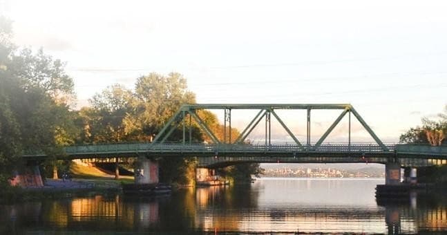 Scenic steel bridge spanning Erie Canal at warm dusk light