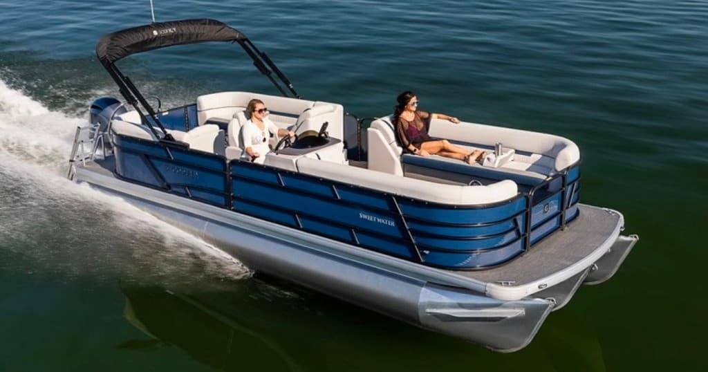 Friends relaxing on blue pontoon boat cruising a green lake