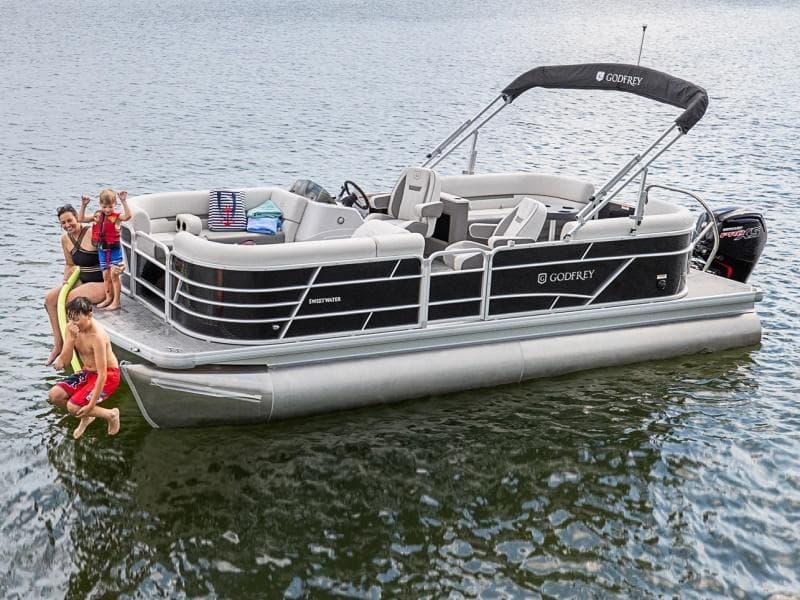 Family enjoying pontoon boat cruise on scenic lake