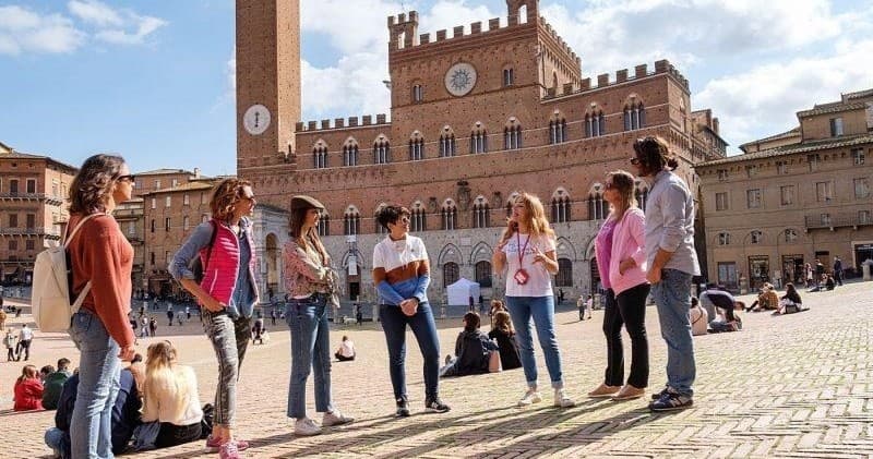 Walking tour group in historic Piazza del Campo, Siena