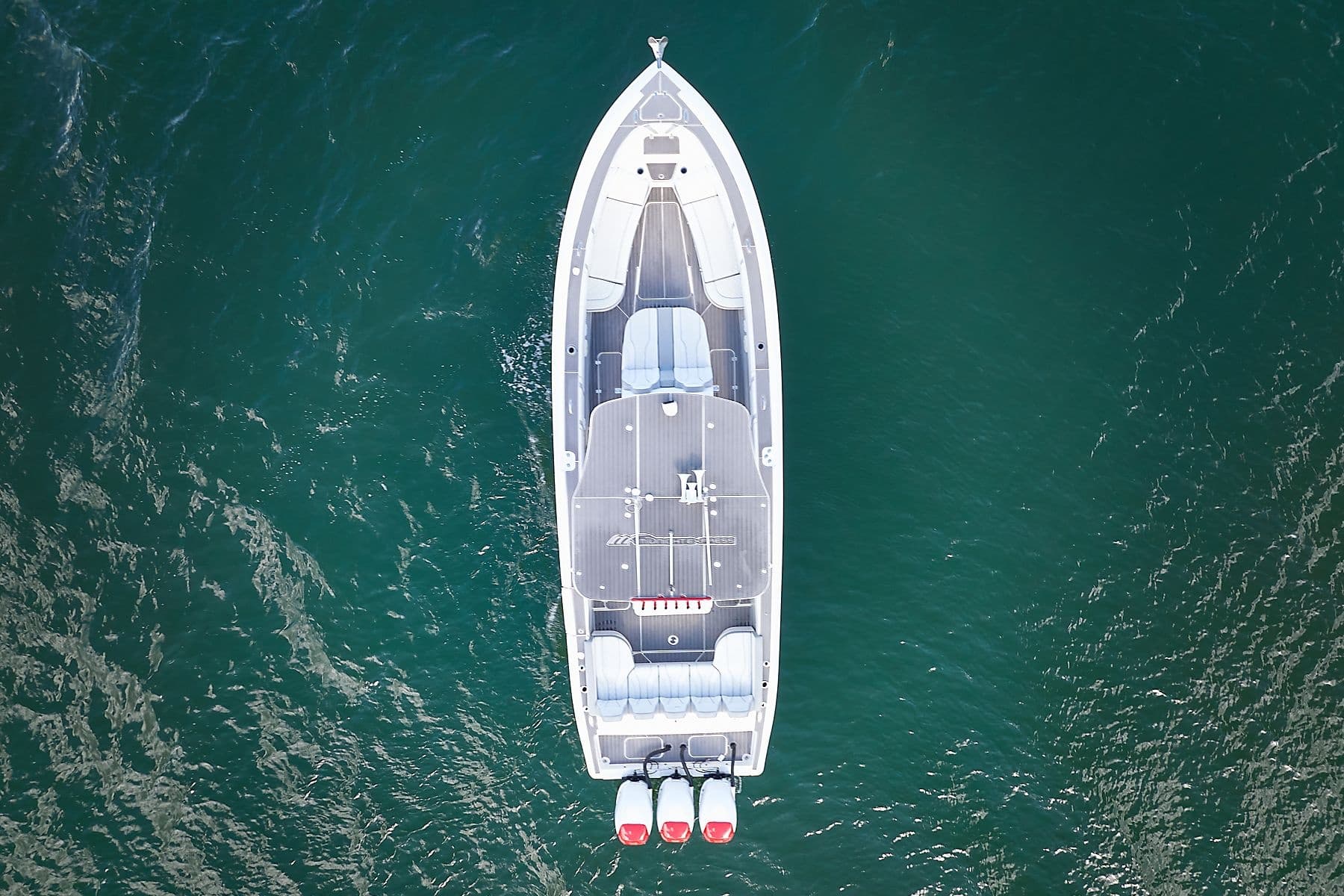 Aerial top-down view of speedboat cruising green coastal waters