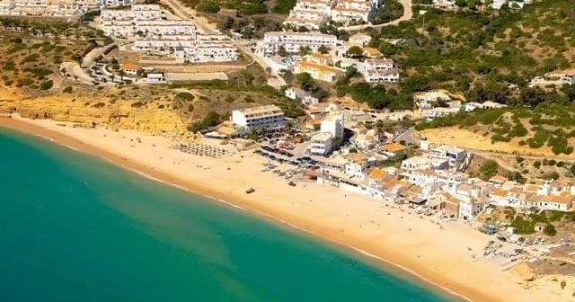 Aerial view of beach and turquoise bay with coastal town