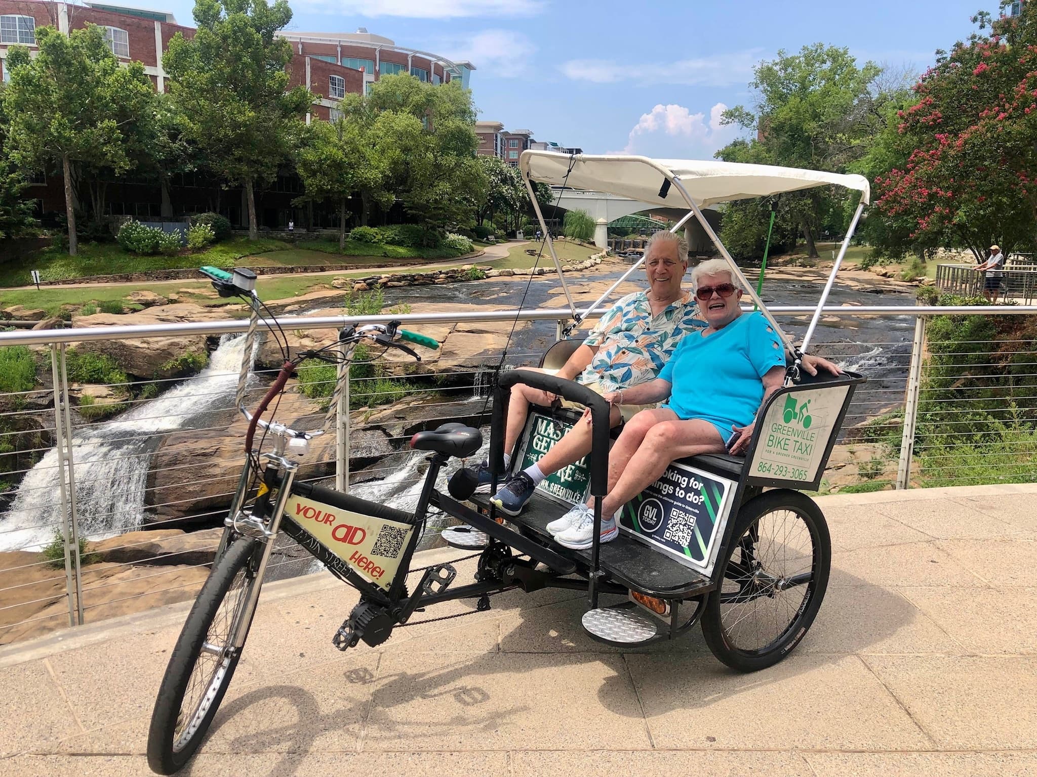 Pedicab riders enjoying waterfall park scenery in Greenville