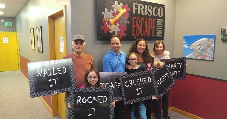 Family group posing at Frisco Escape Room after success