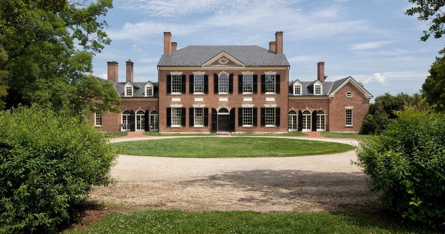 Grand Woodlawn mansion facade with sweeping lawn and sky