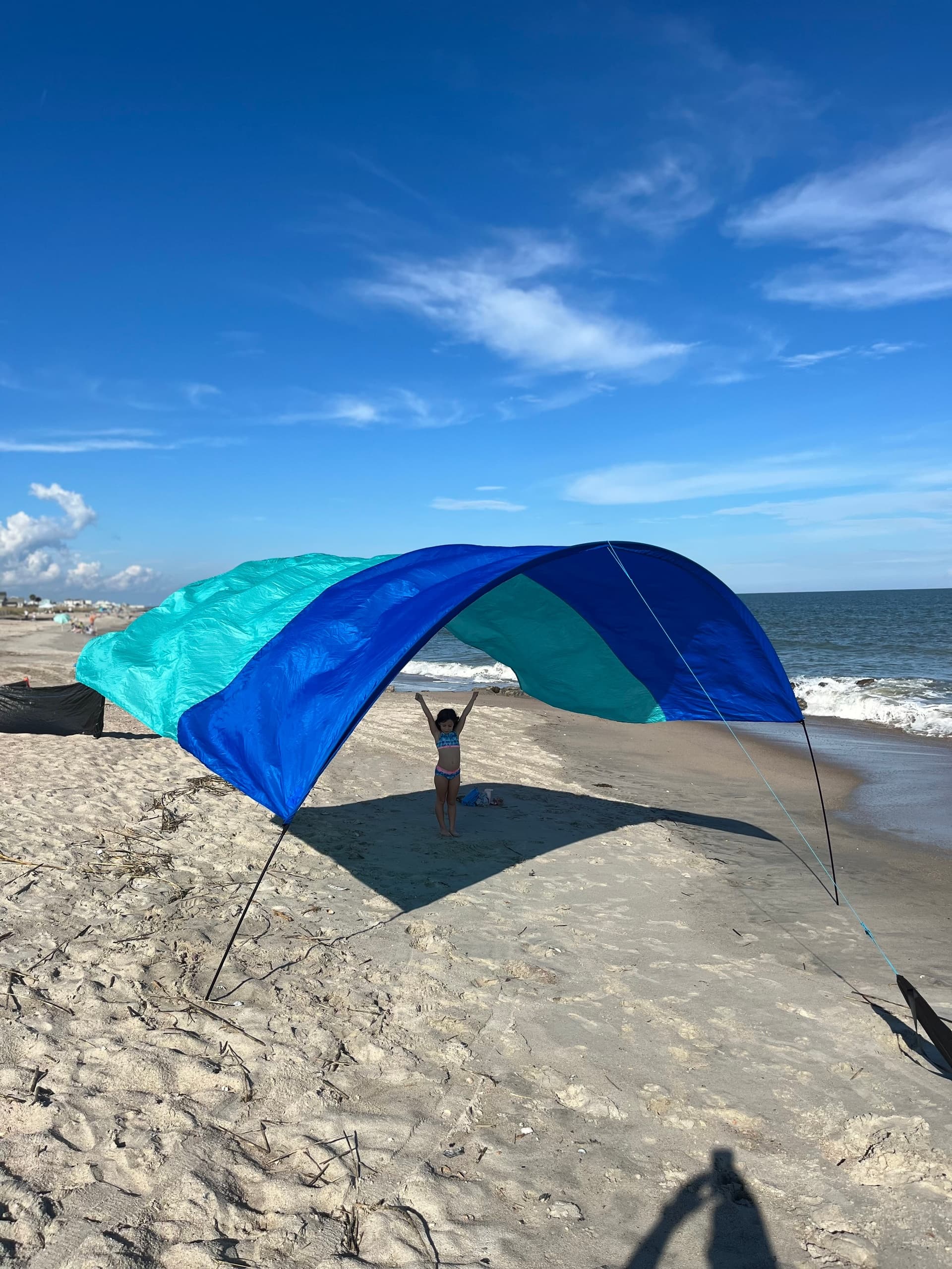 Wind-curved beach canopy and sunbather on Edisto sand
