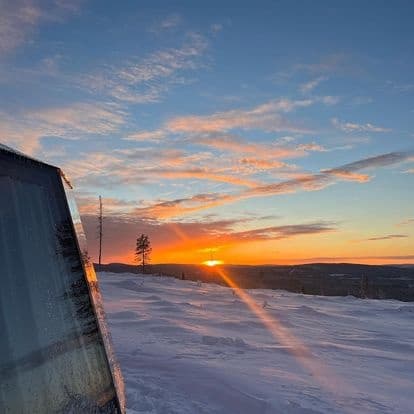 Sunrise over snowy ridge from mountain cabin with panoramic view