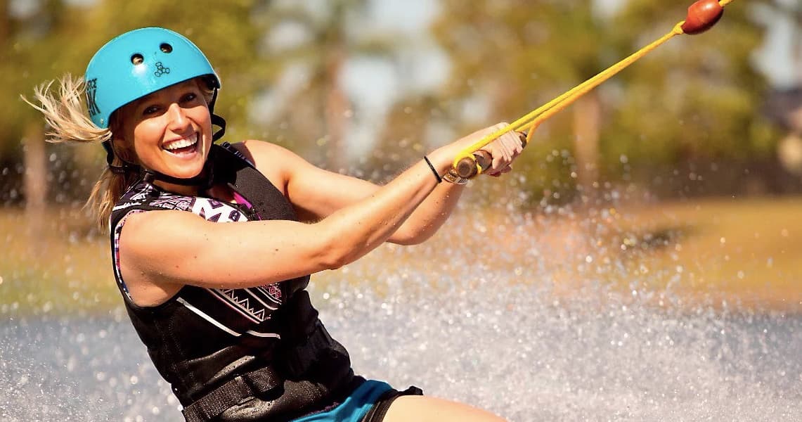 Smiling woman wakeboarding through spray at Cairns wake park