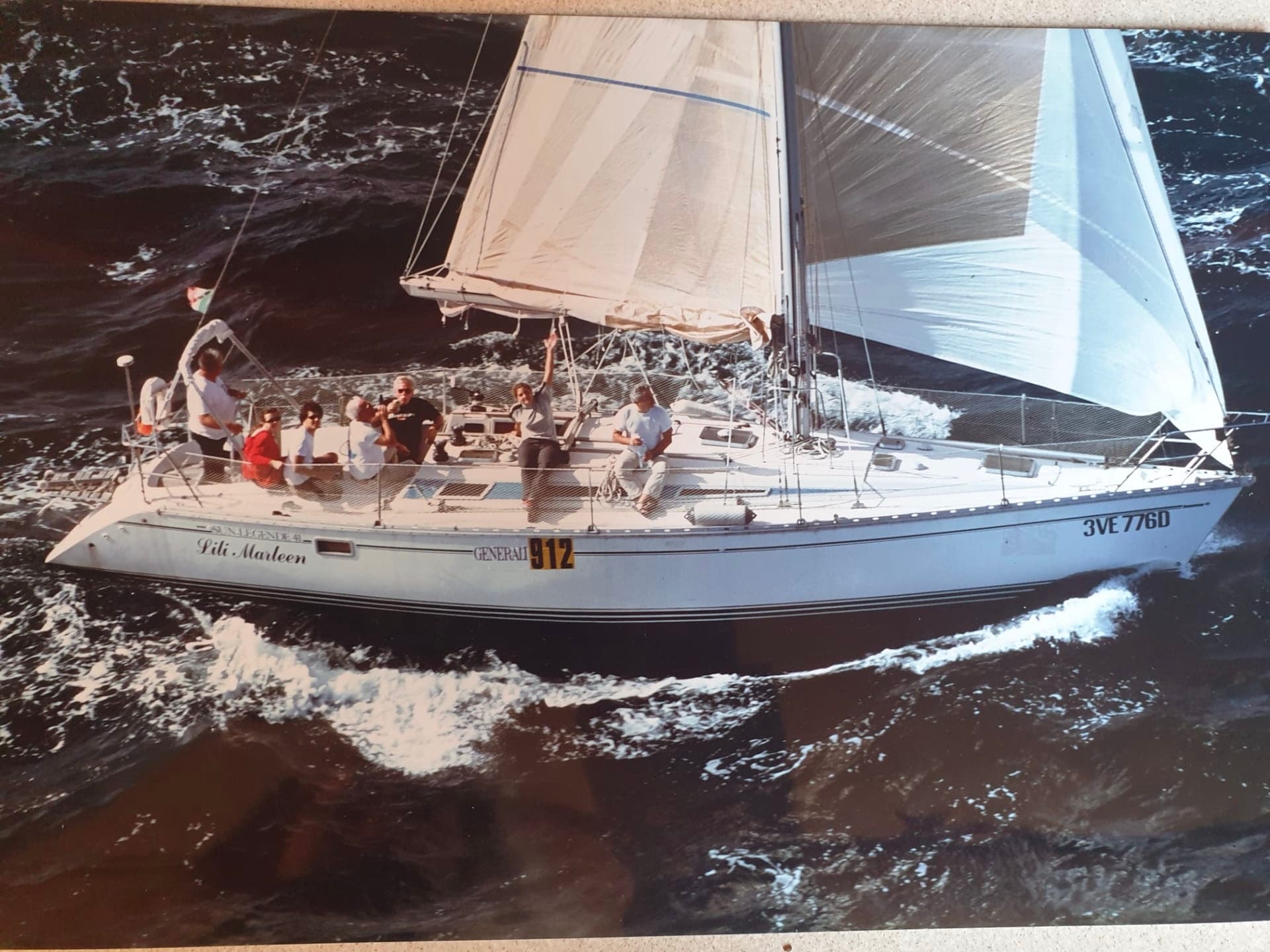 Racing sailboat cutting through rough open ocean waters