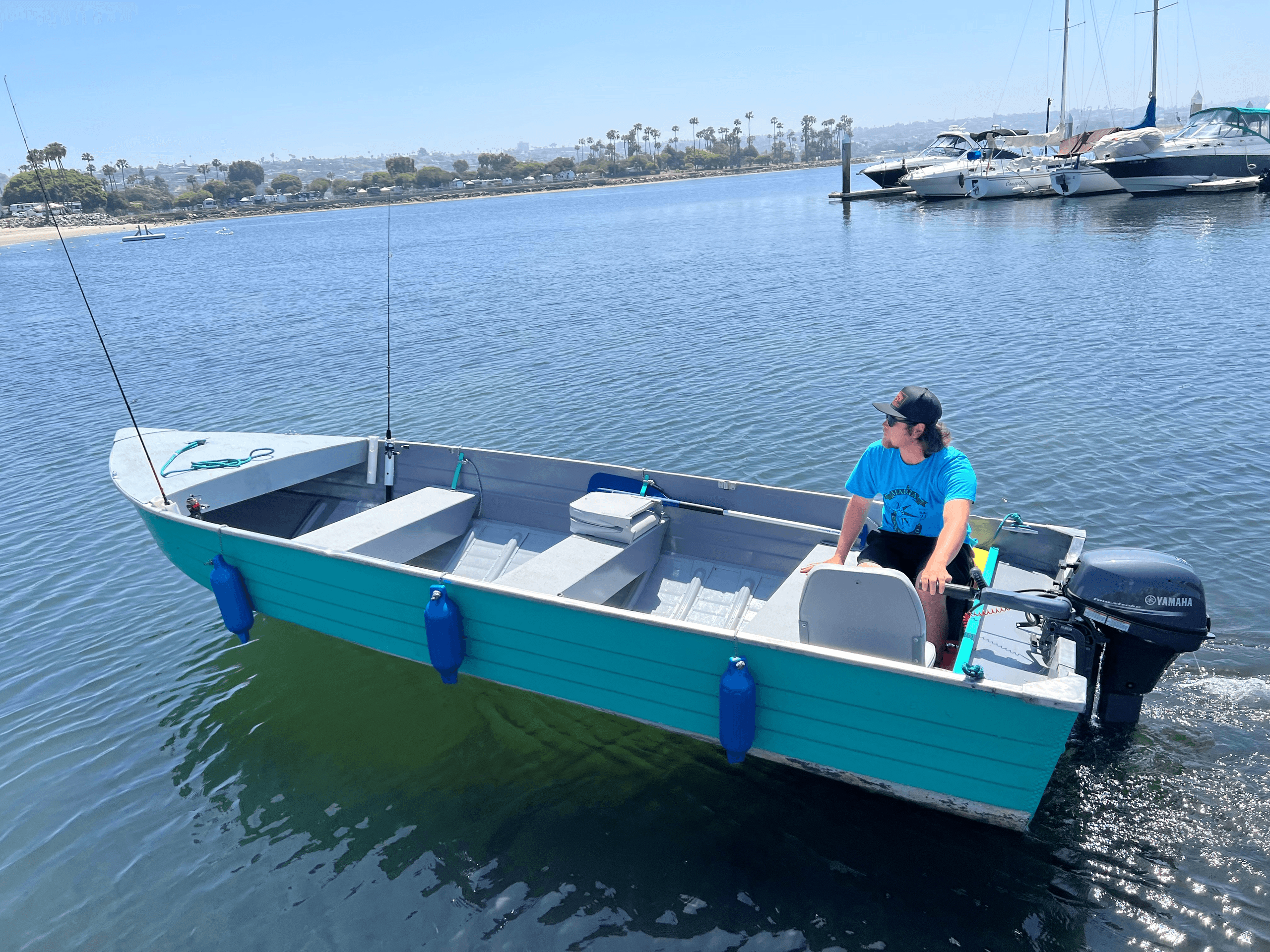 Person piloting small motorboat in marina at Campland