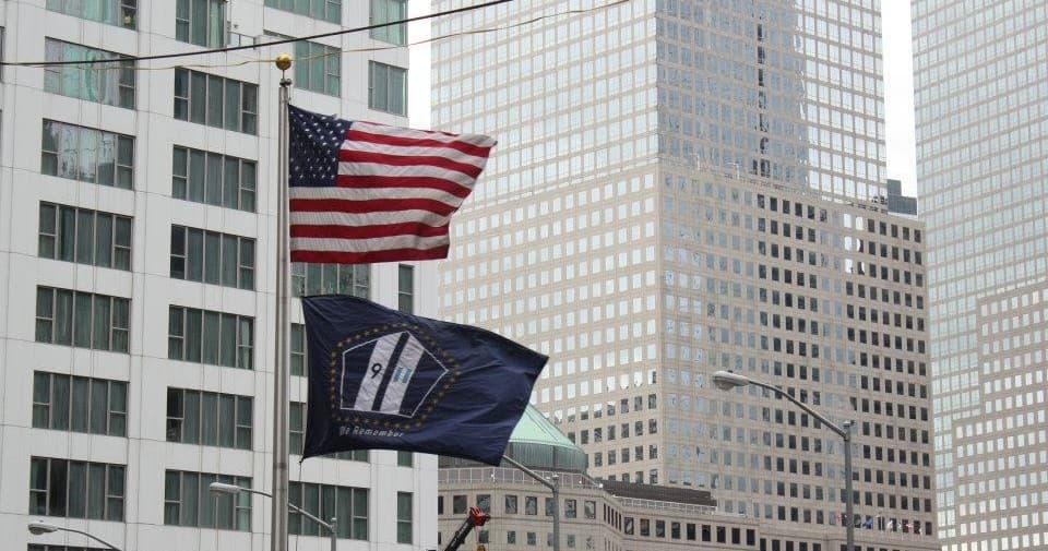 American flag flying by Manhattan skyscrapers, urban sightseeing