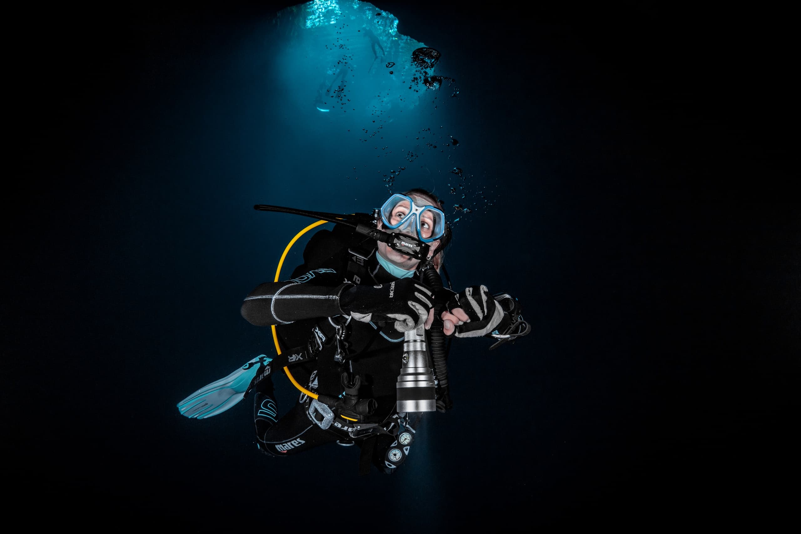 Scuba diver illuminated in dark ocean near Kaikoura diving
