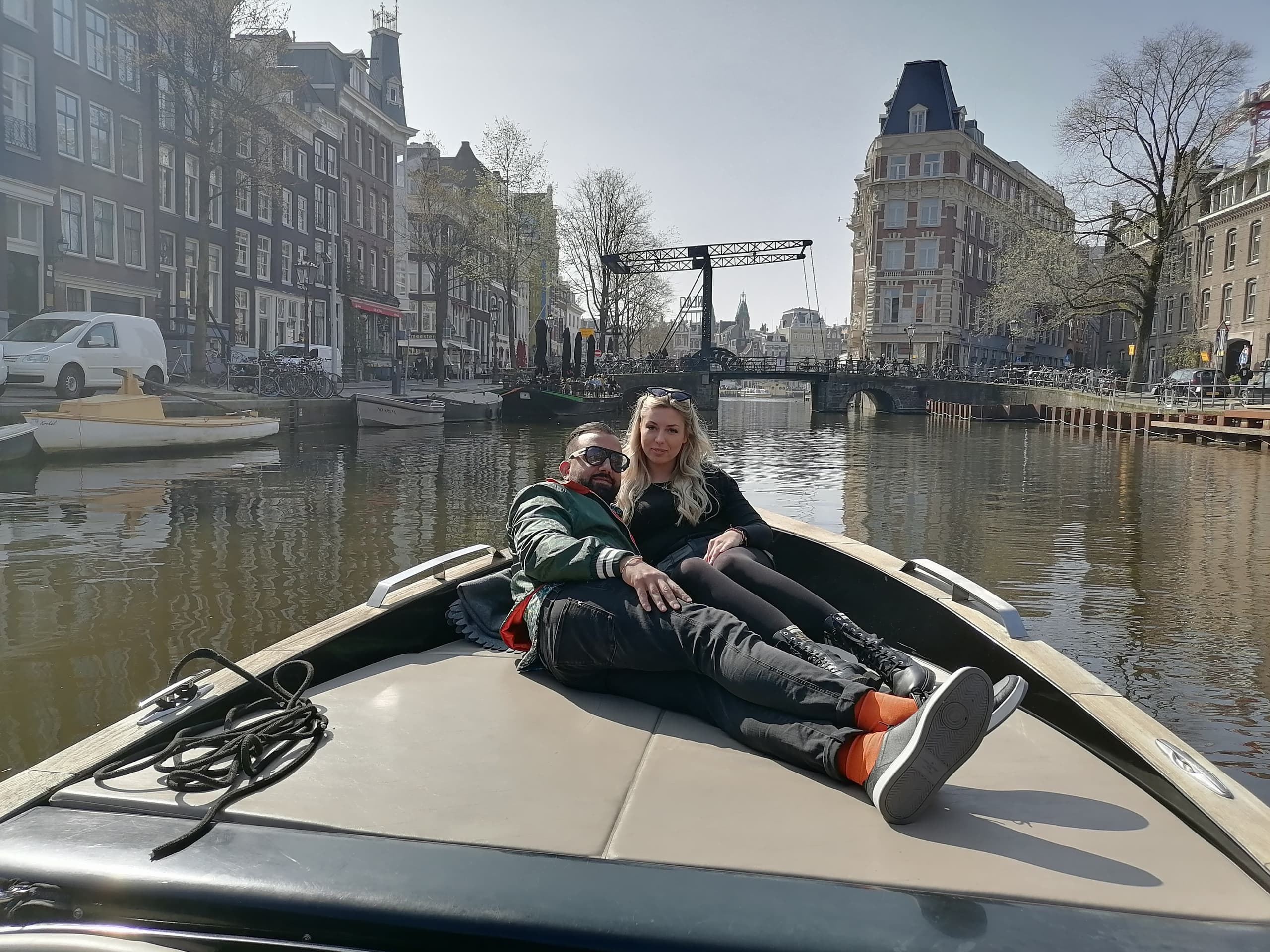 Couple relaxing on boat bow cruising Amsterdam canal