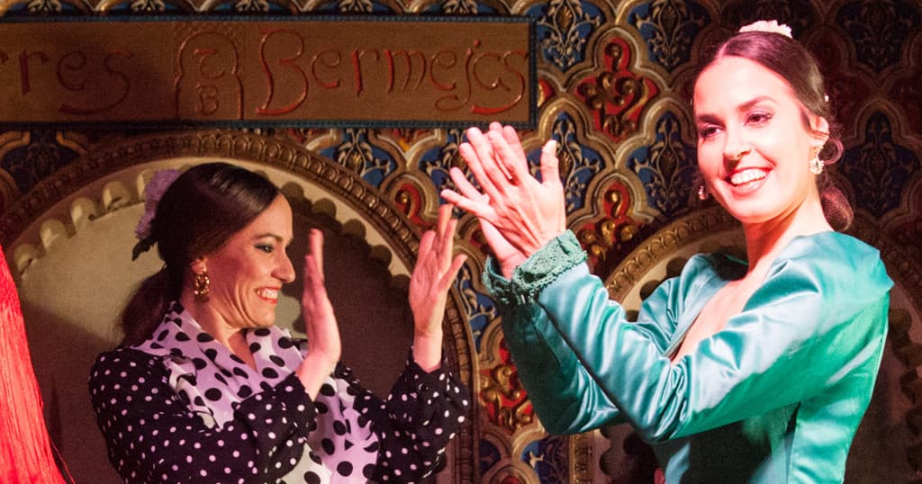 Flamenco performers clapping on ornate indoor stage at Torres Bermejas