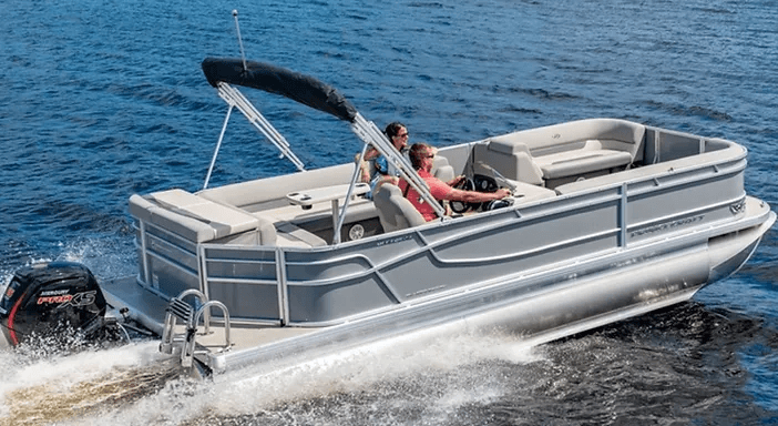 Pontoon boat cruising on lake with passengers enjoying watersports