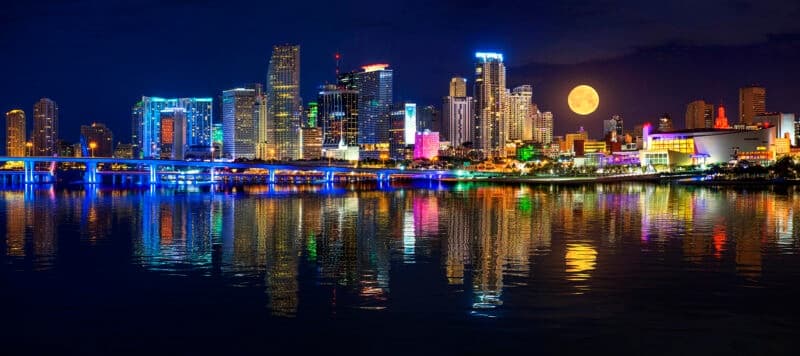Miami skyline illuminated at night reflecting on Biscayne Bay waterfront