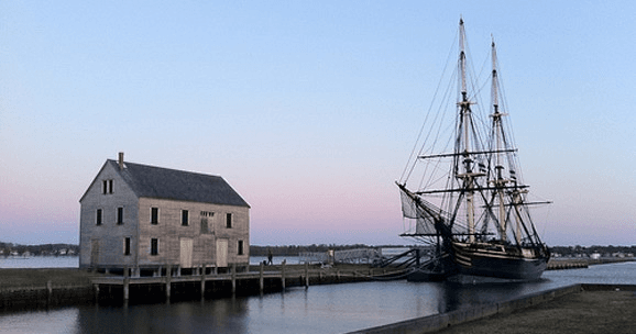 Historic tall ship docked at Salem waterfront at dusk