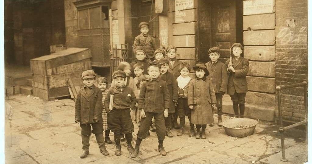 Group of children posed on a historic urban tenement street