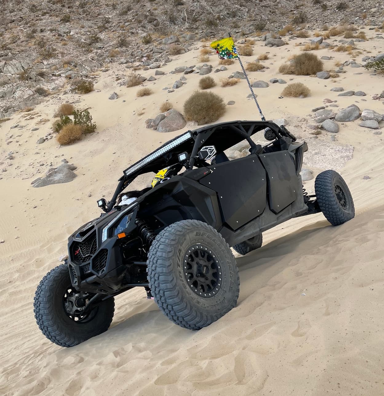 Off-road UTV driving up sand dunes in desert adventure