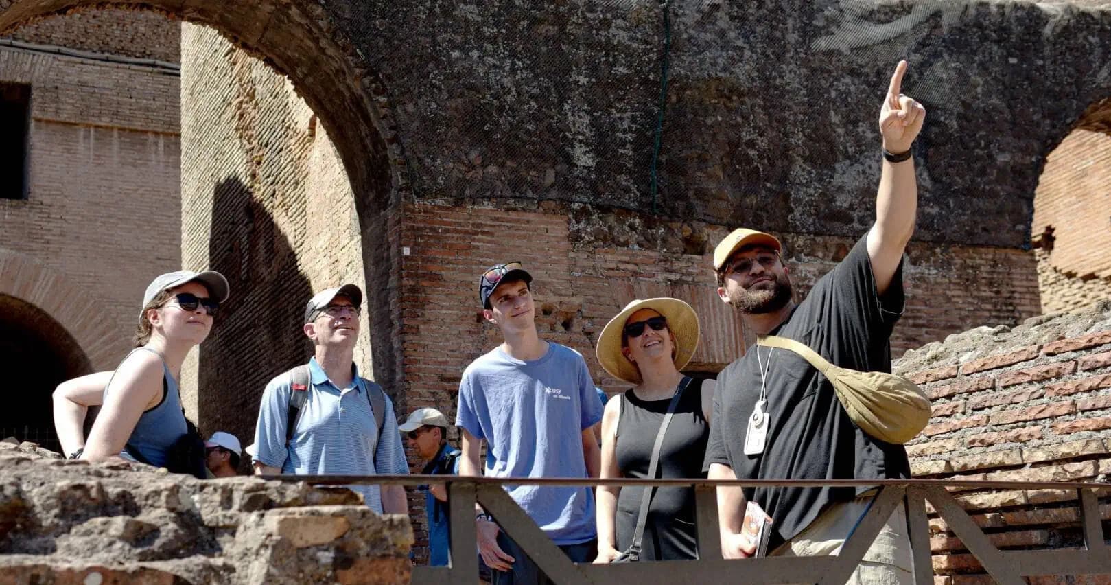 Guided walking tour group exploring ancient Roman ruins outdoors