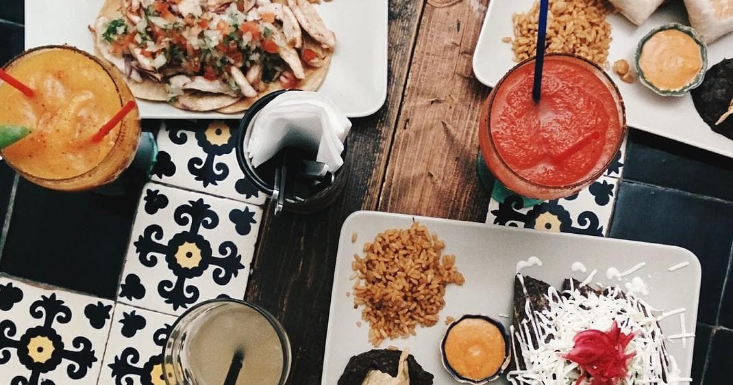 Overhead spread of Portuguese dishes and cocktails at Algarve cafe