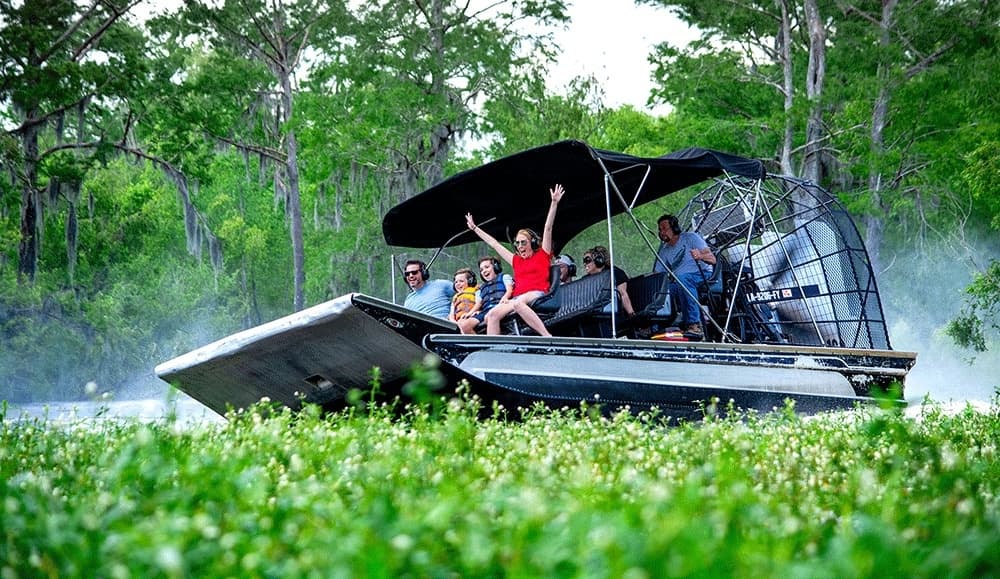 Airboat excursion speeding through Louisiana marsh with passengers