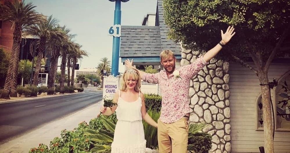 Couple celebrating elopement outside Storybook wedding chapel with palms