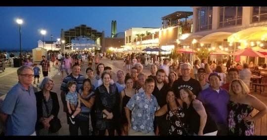 Group of food tour participants posing on outdoor boardwalk