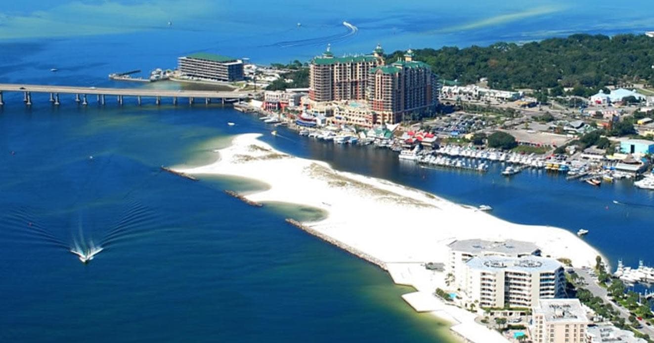 Aerial view of white sand beach and coastal pier in Emerald Coast
