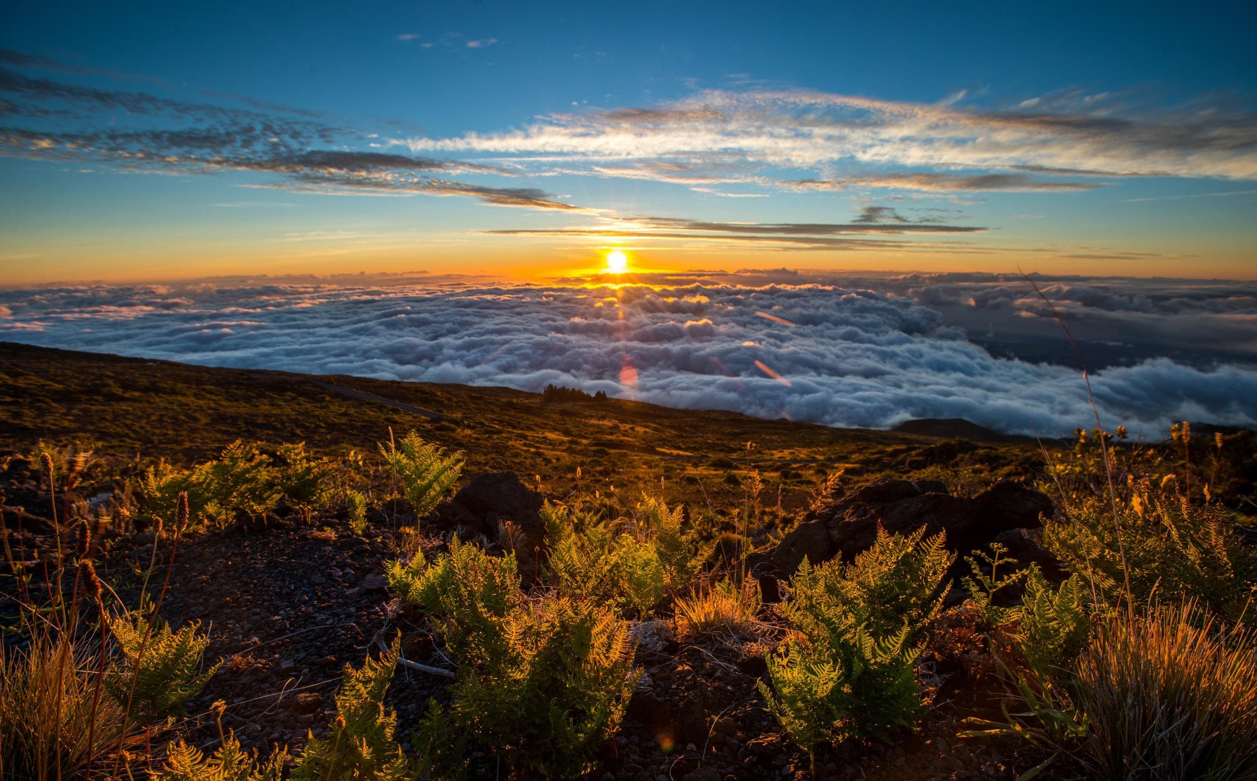 Sunset vista from mountain ridge overlooking clouds and sea