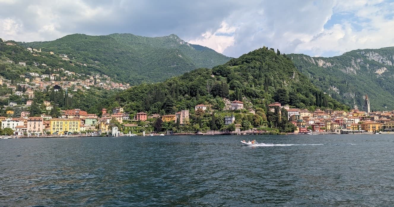 Panoramic Lake Como town view from water, scenic hillside harbor