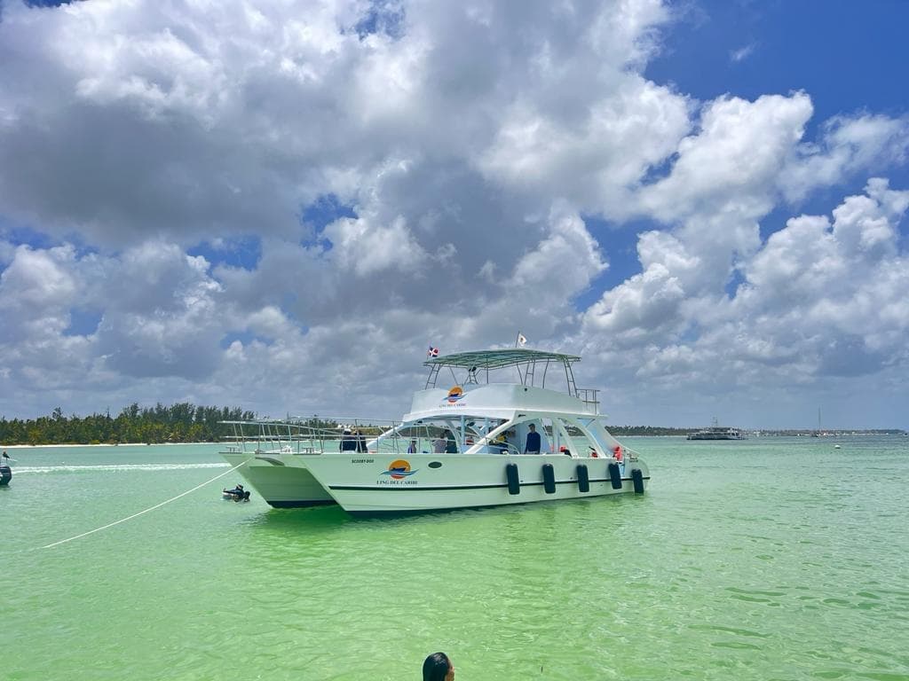 Charter boat anchored in shallow emerald lagoon for snorkeling