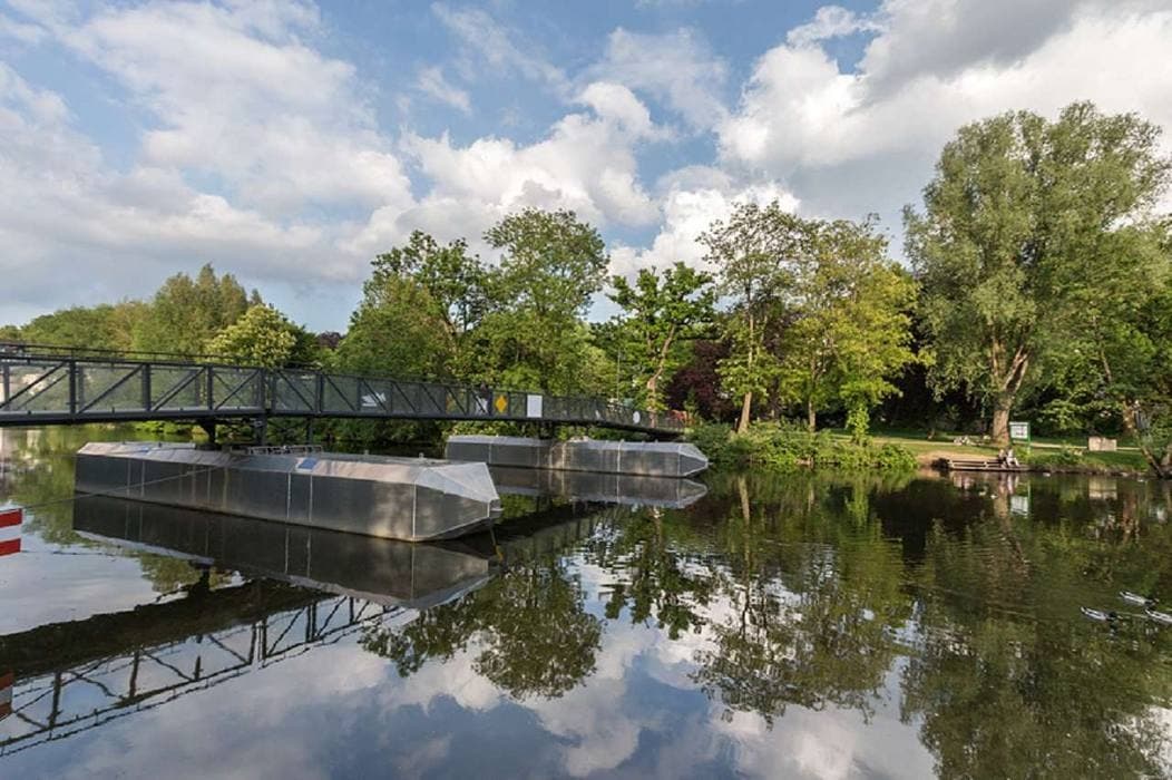 Calm river with modern footbridge and reflections on Lahn