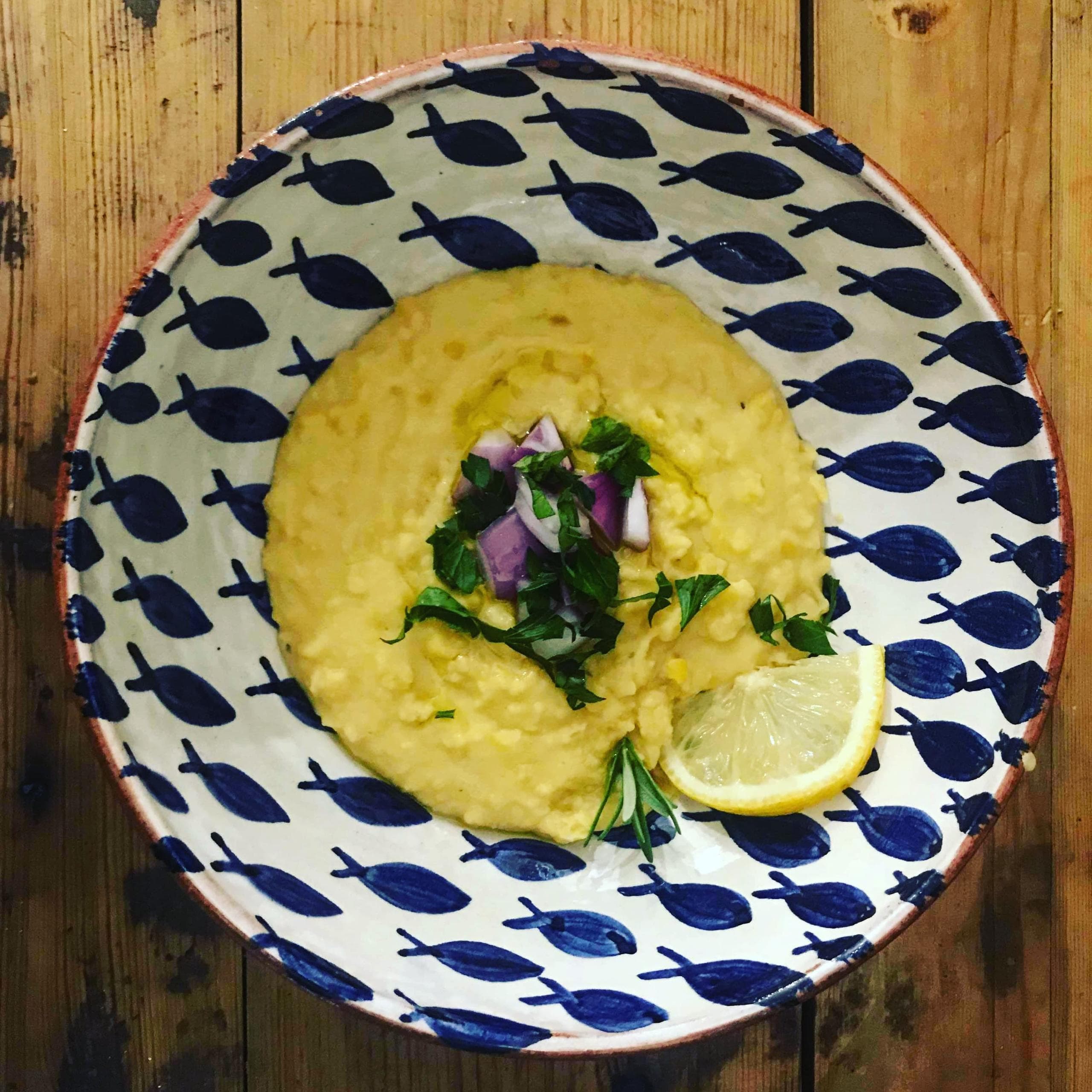 Creamy chickpea dip served in patterned bowl on wooden table