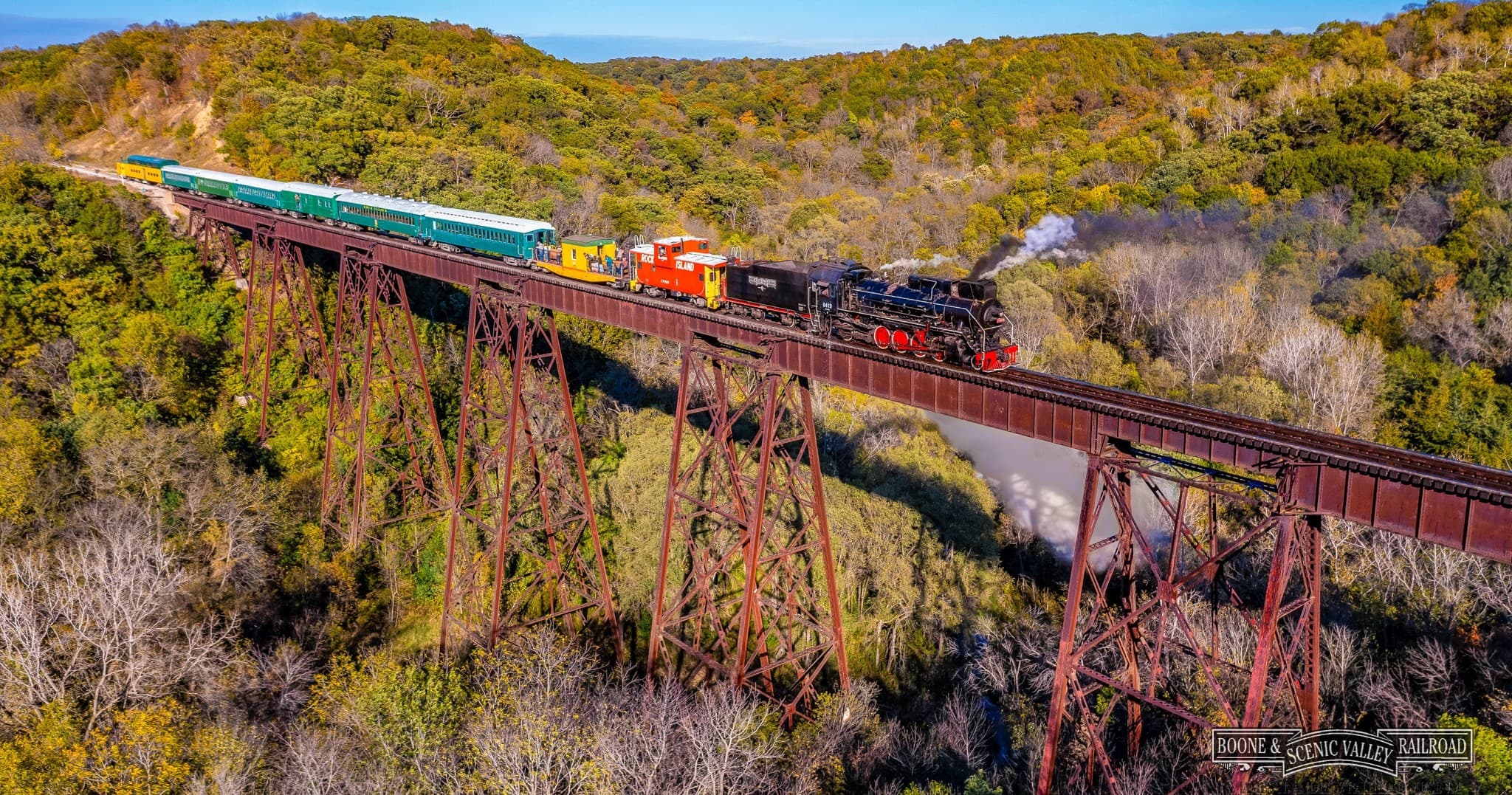 Scenic train crossing high trestle over forested valley